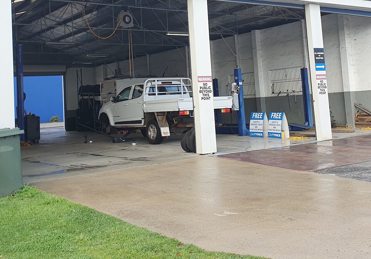 Both workshop bays open at Clark Tyres with a ute up on the hoist